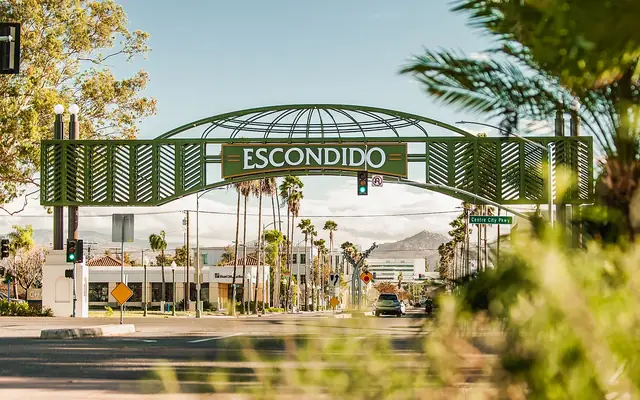 The Escondido arch sign over Grand Avenue, lined with palm trees
