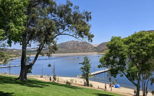 Lake Poway seen from the park lawn, with trees and hills behind