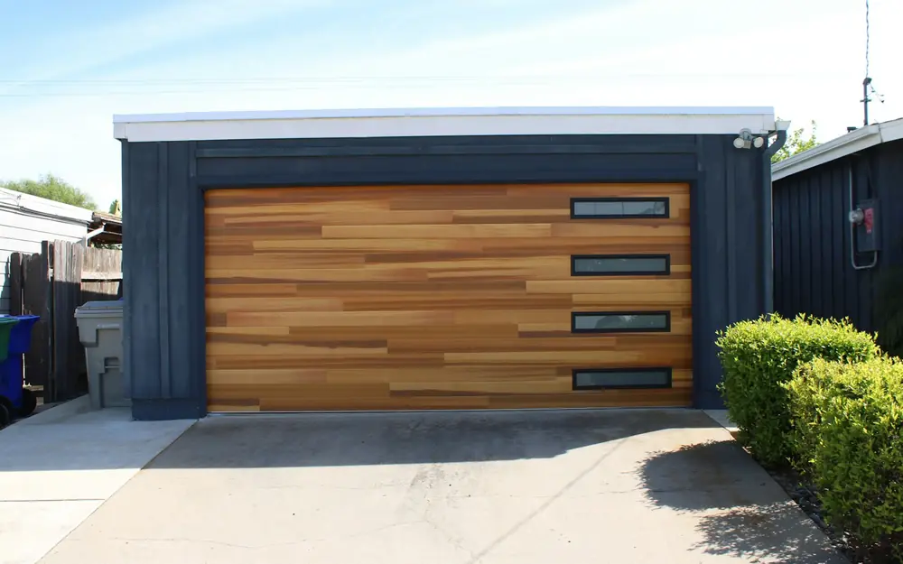 A wood-panel garage door on a dark house